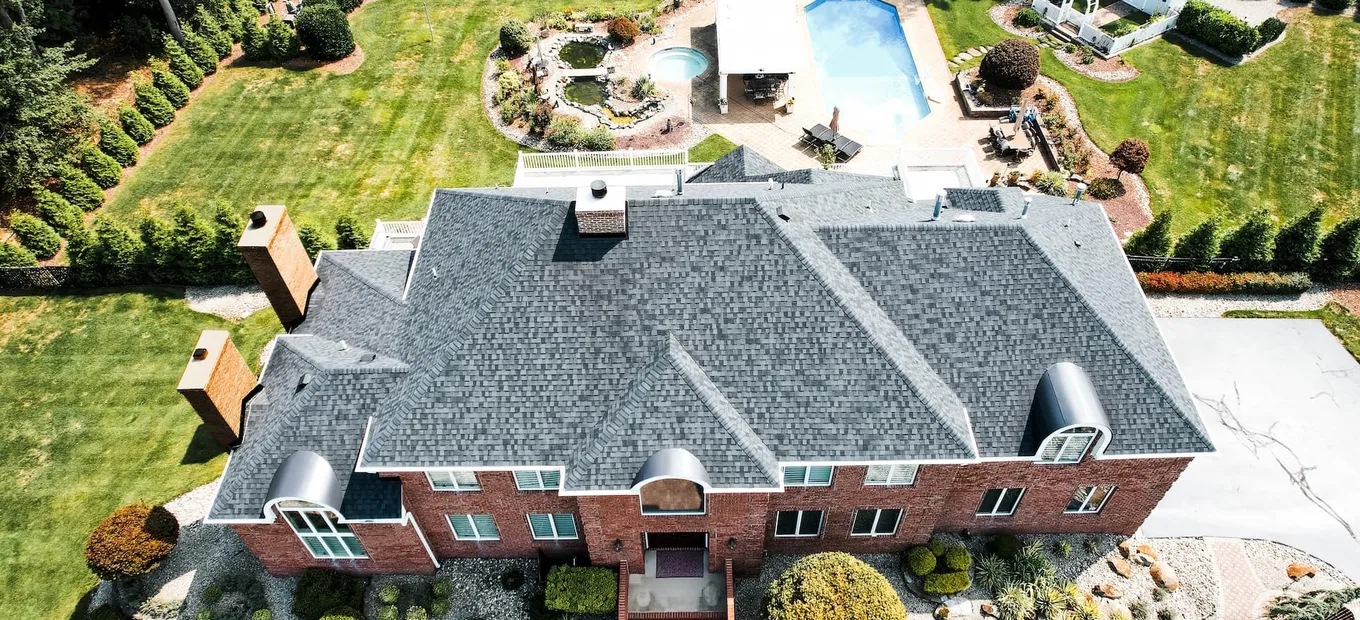 Aerial view of a New Jersey brick home with twin masonry chimneys exposed to winter freeze-thaw weather