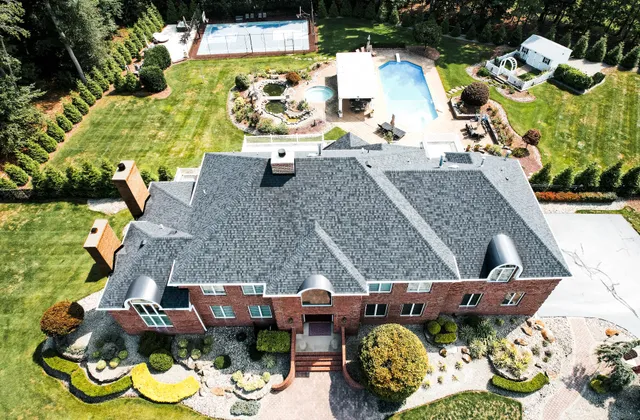 Aerial view of a New Jersey brick home with twin masonry chimneys exposed to winter freeze-thaw weather