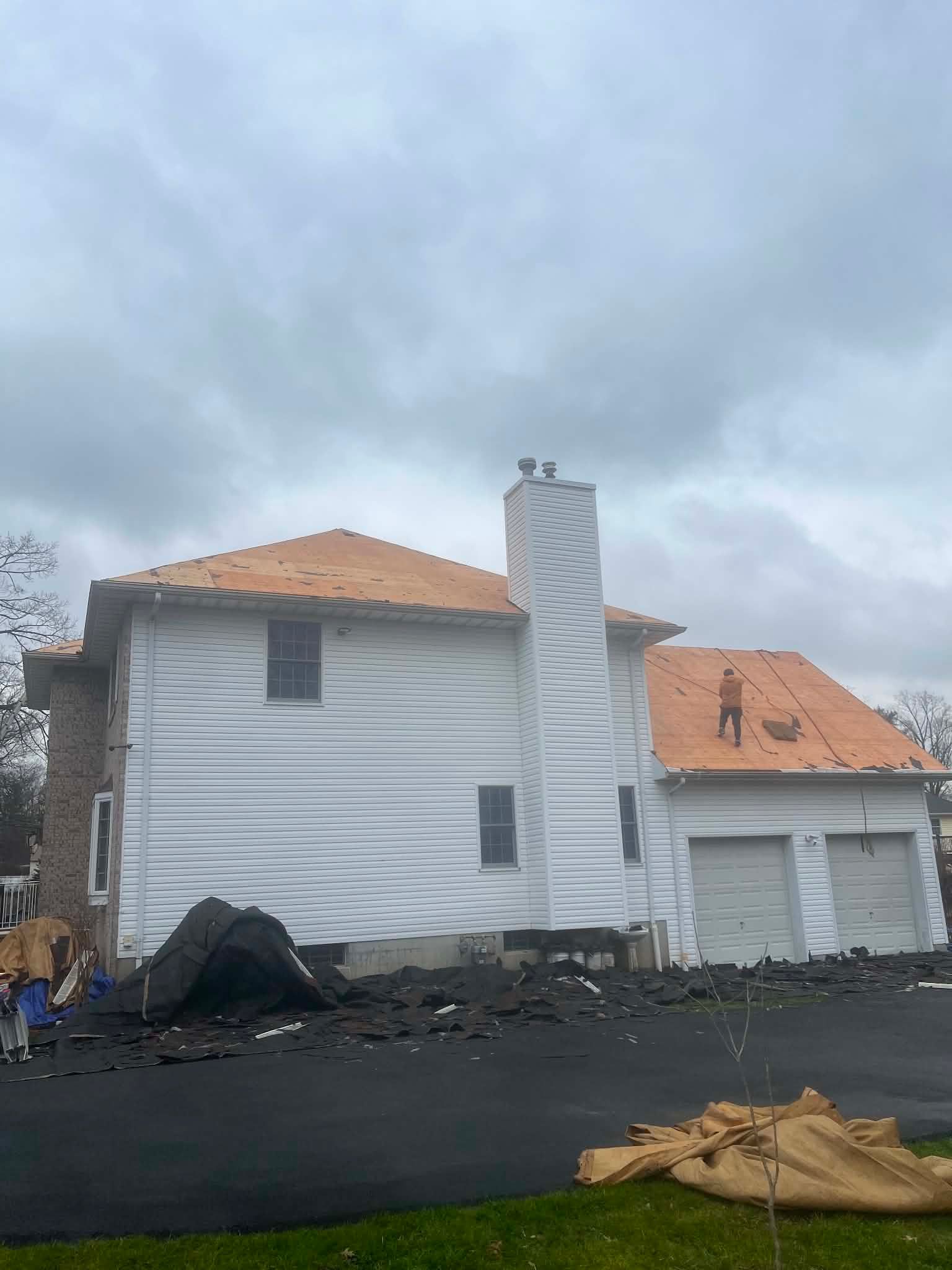 Chimney exposed during a full roof tear-off — Legacy Peak Roofing & Construction, New Jersey