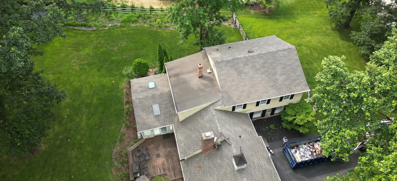 Aerial view of a New Jersey split-level home with a lower flat-roofed wing meeting the main pitched roof