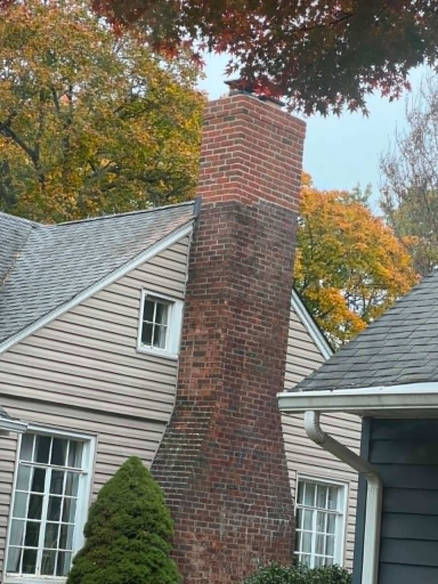 Leaning brick chimney before masonry repair — Legacy Peak Roofing & Construction, New Jersey